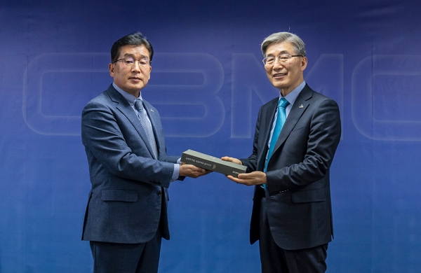 이대식 중앙회장(우)이 송완주 70주년 TF팀장(좌)으로부터 이번에 발간된 한국CBMC 70년사 책자를 전달받고 있다.