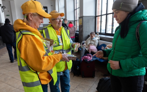 루마니아 수체아바 시의 기차역에서 미국 남침례교 재난 구호팀(SBDR)의 자원 봉사자들(왼쪽)이 우크라이나 난민에게 초콜릿 우유와 주스 상자를 제공하고 있다.