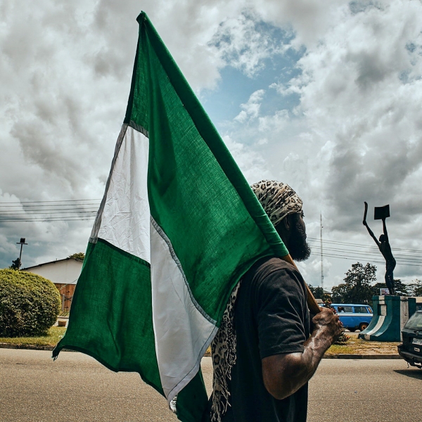 한 남성이 나이지리아 국기를 들고 있다. 나이지리아에서는 이슬람 극단주의 단체들과 무장 괴한들, 갱단 등이 연대하면서 정국의 혼란이 극심해질 것으로 예상한다.