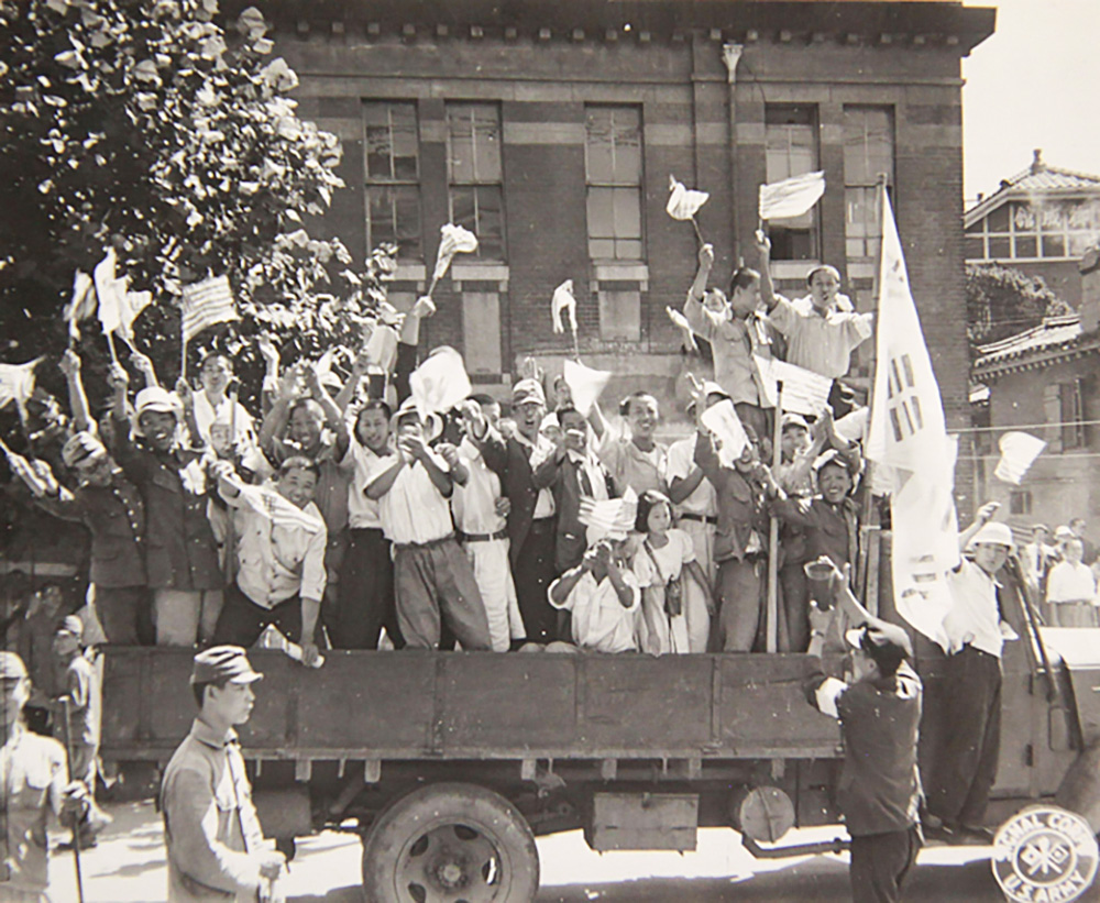 광복 이후 1945년 9월 9일, 태극기와 성조기를 함께 든 시민이 광복의 기쁨을 누리고 있다.