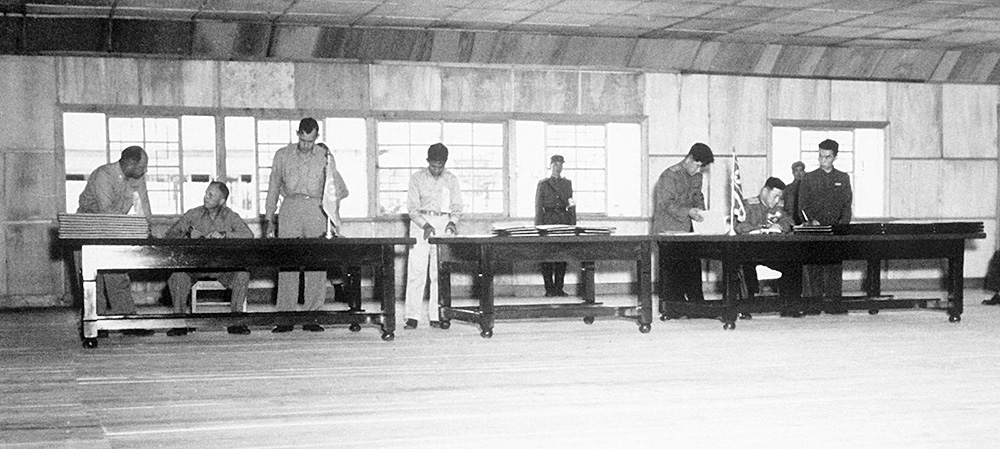 1953년 7월 27일, 정전협상장으로 쓰던 판문점 목조건물에서 휴전협정이 진행됐다. 왼쪽 책상에 윌리엄 해리슨 유엔군사령부 중장, 오른쪽 책상에 남일 조선인민군 대장이 앉아 서명했다.
